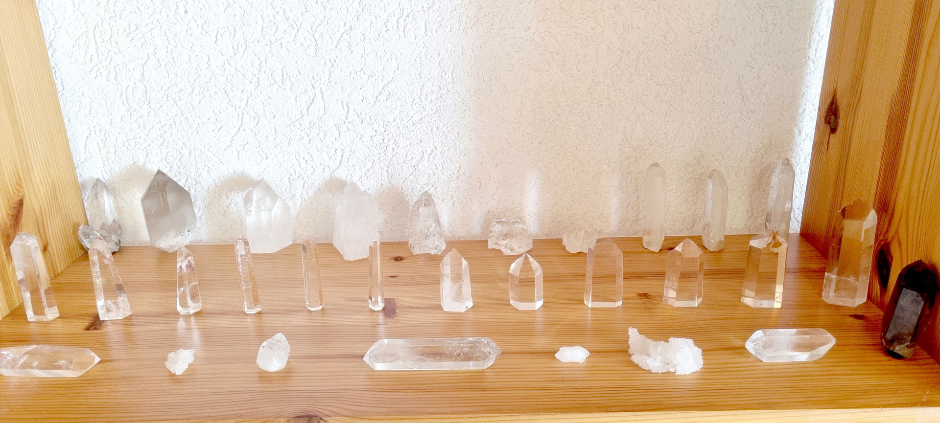 de multiples critaux de quartz sur une étagère en bois